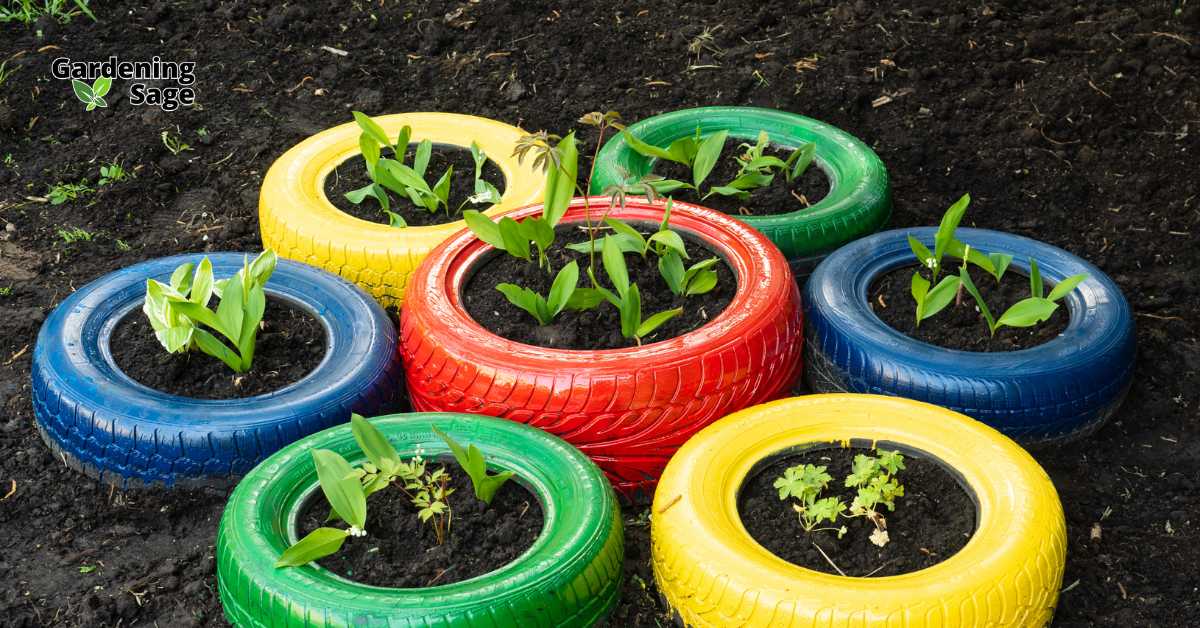 Brightly colored tires repurposed as planters with young plants growing in them, illustrating creative and sustainable garden design through upcycling.